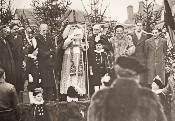 Saint Nicolas en personne, entouré des enfants et des notables.