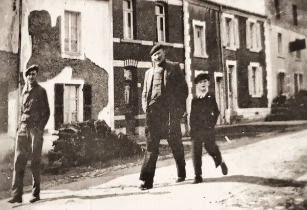 Lucien Minguet, Jean Jean (Jean Demesmaeker) et Jean Hamers descendent la rue principale. La photo montre l'état délabré des façades. Le quartier est…