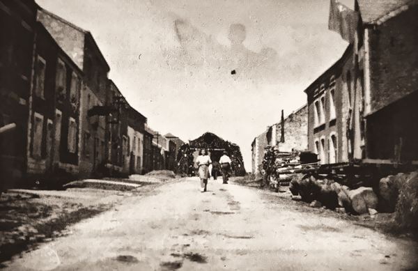 La photo date des années quarante. La route, encore empierrée, est entretenue par les services communaux. Jeanine Blaise marche au milieu de la rue…
