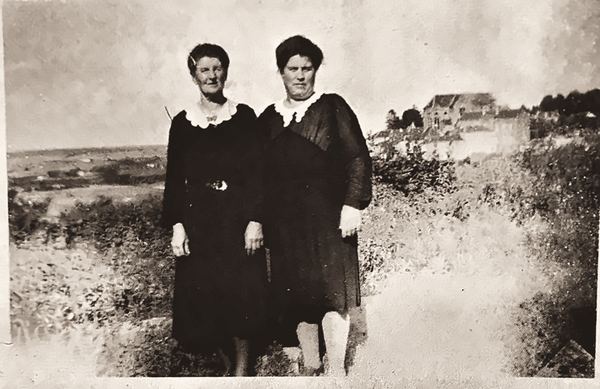 Marie et Alice Malhage sont photographiées à la Chamaillotte. Les bâtiments communaux apparaissent en arrière-plan. Quant à l'église de Florenville, elle…