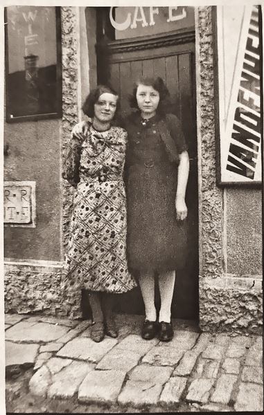 Devant la porte, à droite, Numa Balon et, à gauche, sa cousine. Numa est la fille du propriétaire. Le café cessera son activité en 1938 pour devenir…