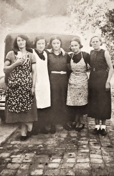 Marie Minguet, Georgette Varnier, Léa Rausch, Lucienne Varnier et Mimi Maury forment une rangée complice devant la voiture d'un particulier « aisé ». C'est…